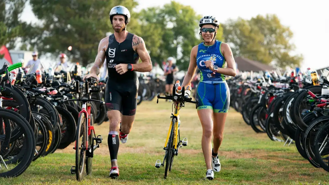 Zawodnicy triathlonu biegną obok rzęd&oacute;w rower&oacute;w. To właśnie triathlon co to za wyzwanie!
