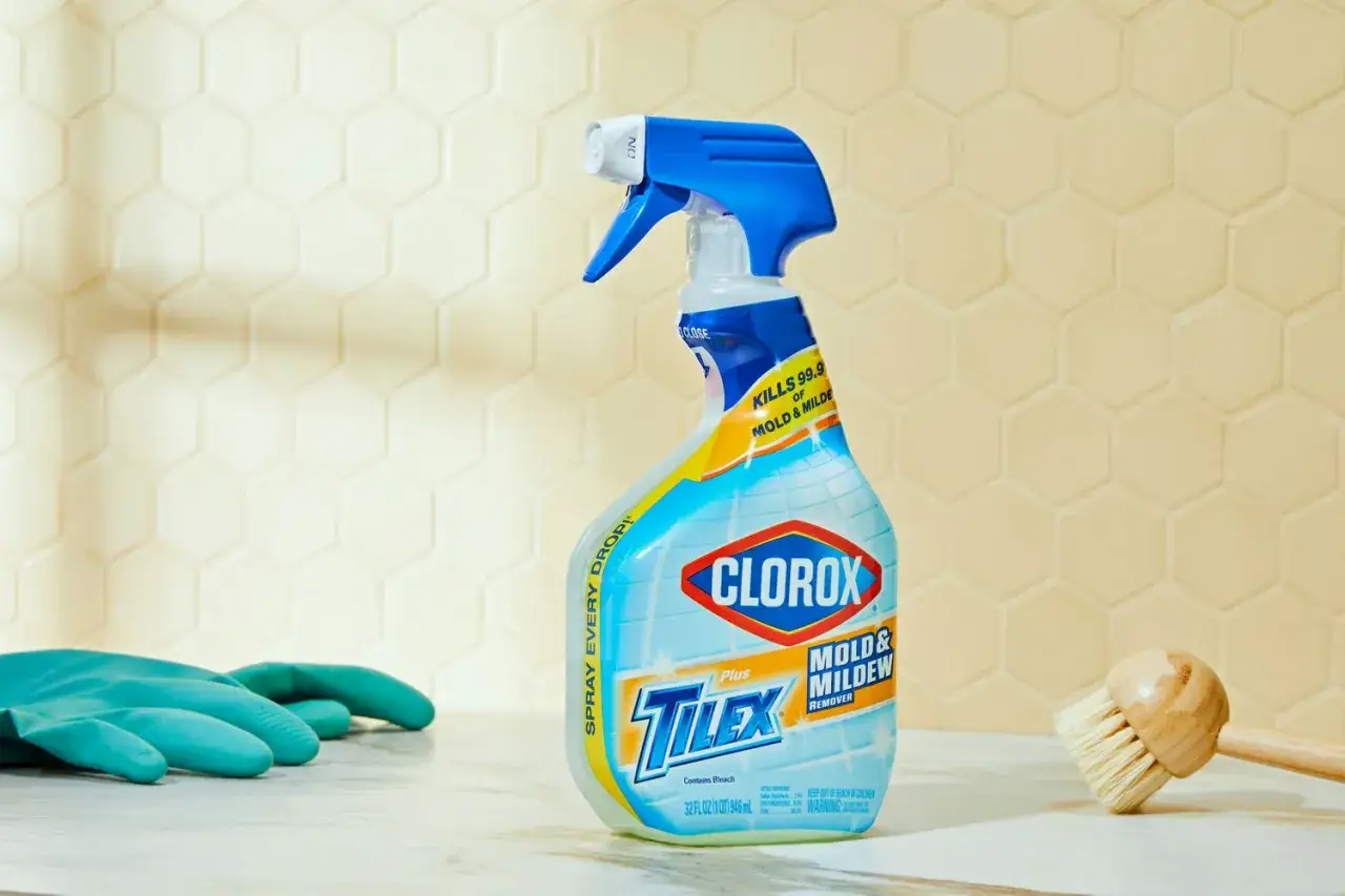 Clorox Tilex spray bottle for black mold removal, with gloves and a brush nearby.