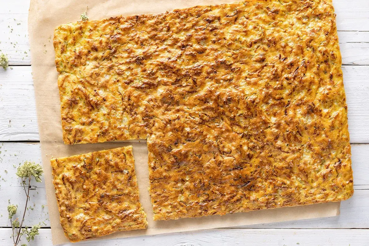 Una dorata schiacciata di zucchine, croccante fuori e morbida dentro, pronta per essere gustata.