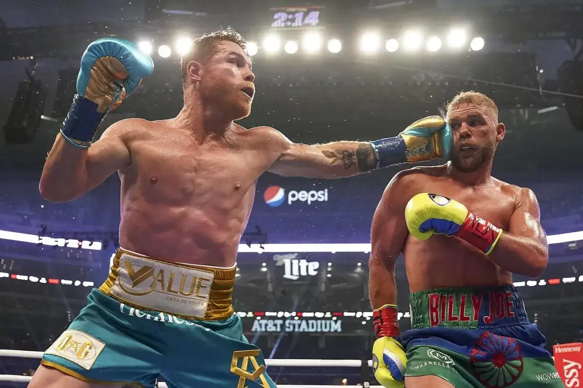 Canelo lands a punch, showcasing his impressive boxing record. The crowd cheers at AT&T Stadium.