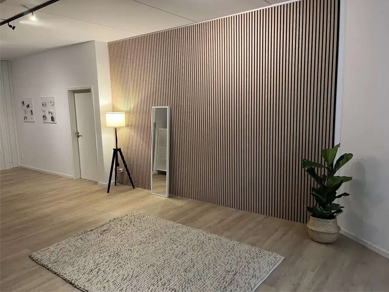 Moderne Akustikpaneele deko ideen: Holzwand mit vertikalen Lamellen, Spiegel, Lampe, Teppich und Pflanze.