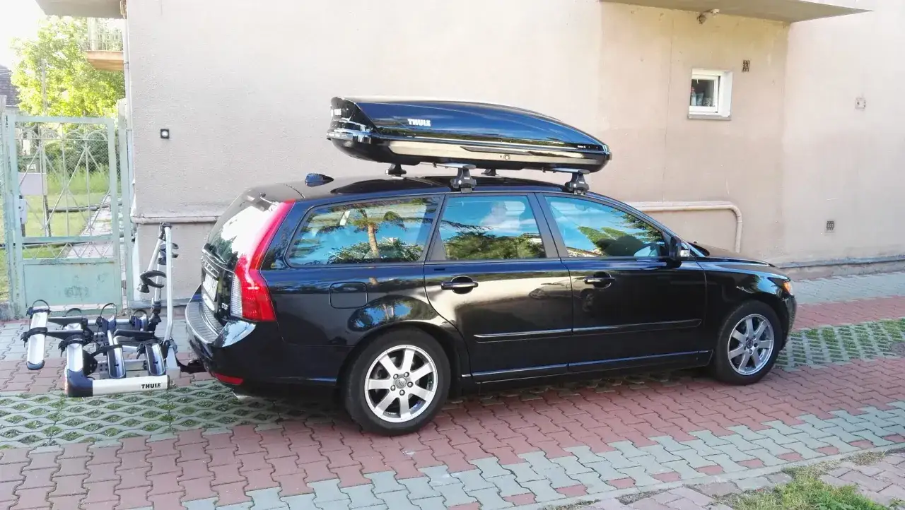 Czarny kombi z boxem dachowym Thule i bagażnikiem rowerowym. Gotowy na wakacje!