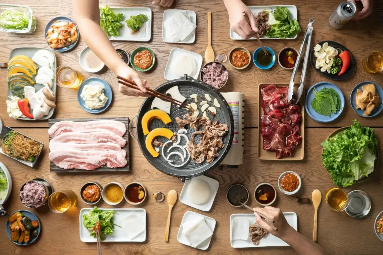 En h&auml;rlig koreansk bbq-m&aring;ltid med grillad biff, fl&auml;sk, gr&ouml;nsaker och kimchi.