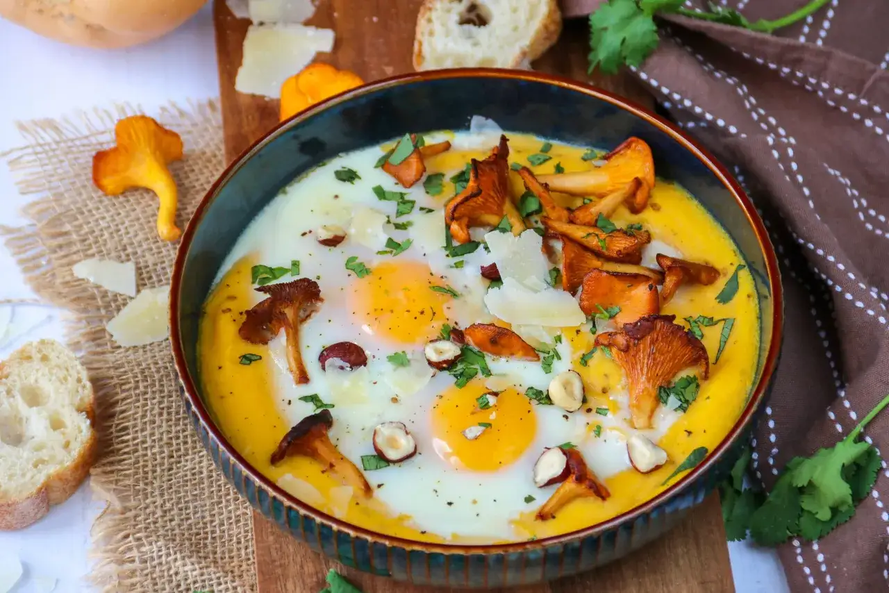 Un plat de oeufs au four avec des champignons, du fromage r&acirc;p&eacute; et des herbes fra&icirc;ches. Un d&eacute;lice pour le petit-d&eacute;jeuner ou un brunch.