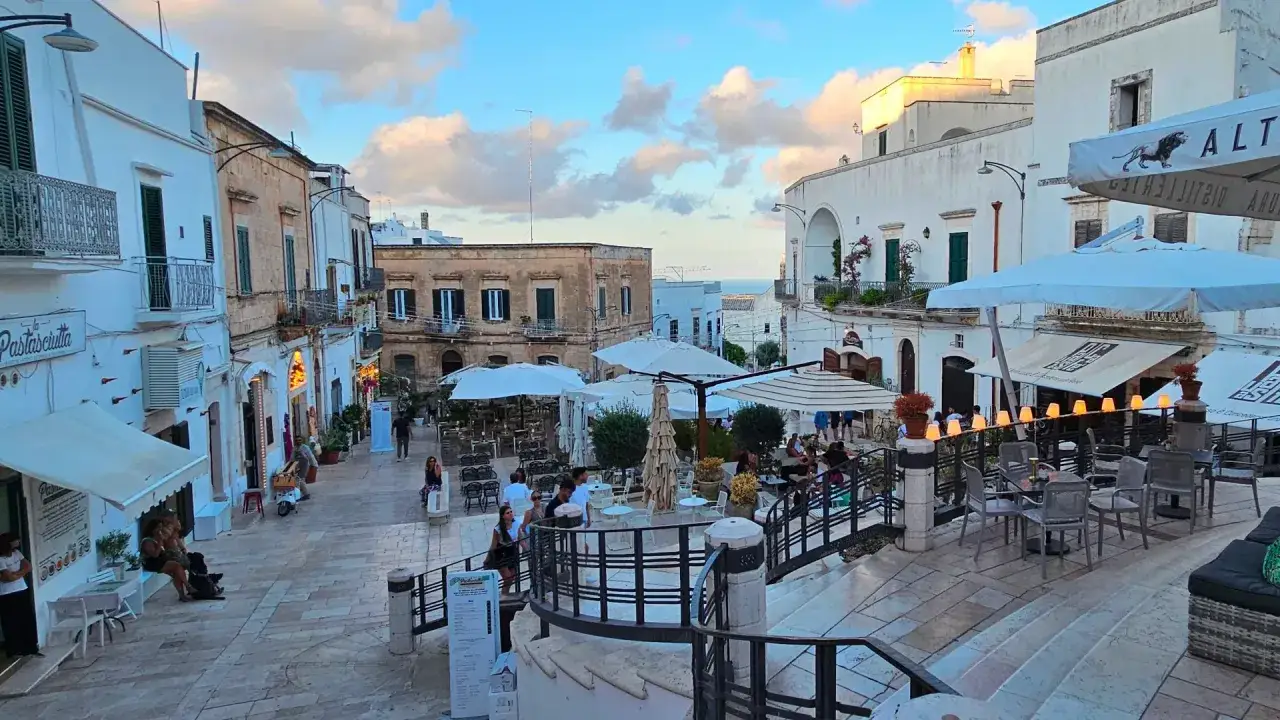 Passeggiata serale a Ostuni: cosa vedere tra vicoli bianchi, ristoranti all'aperto e scorci sul mare.