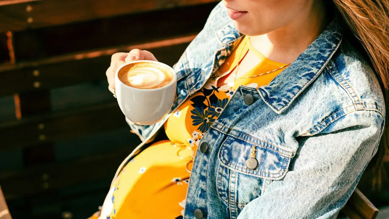 Schwangere Frau mit Kaffee. Die Frage 
