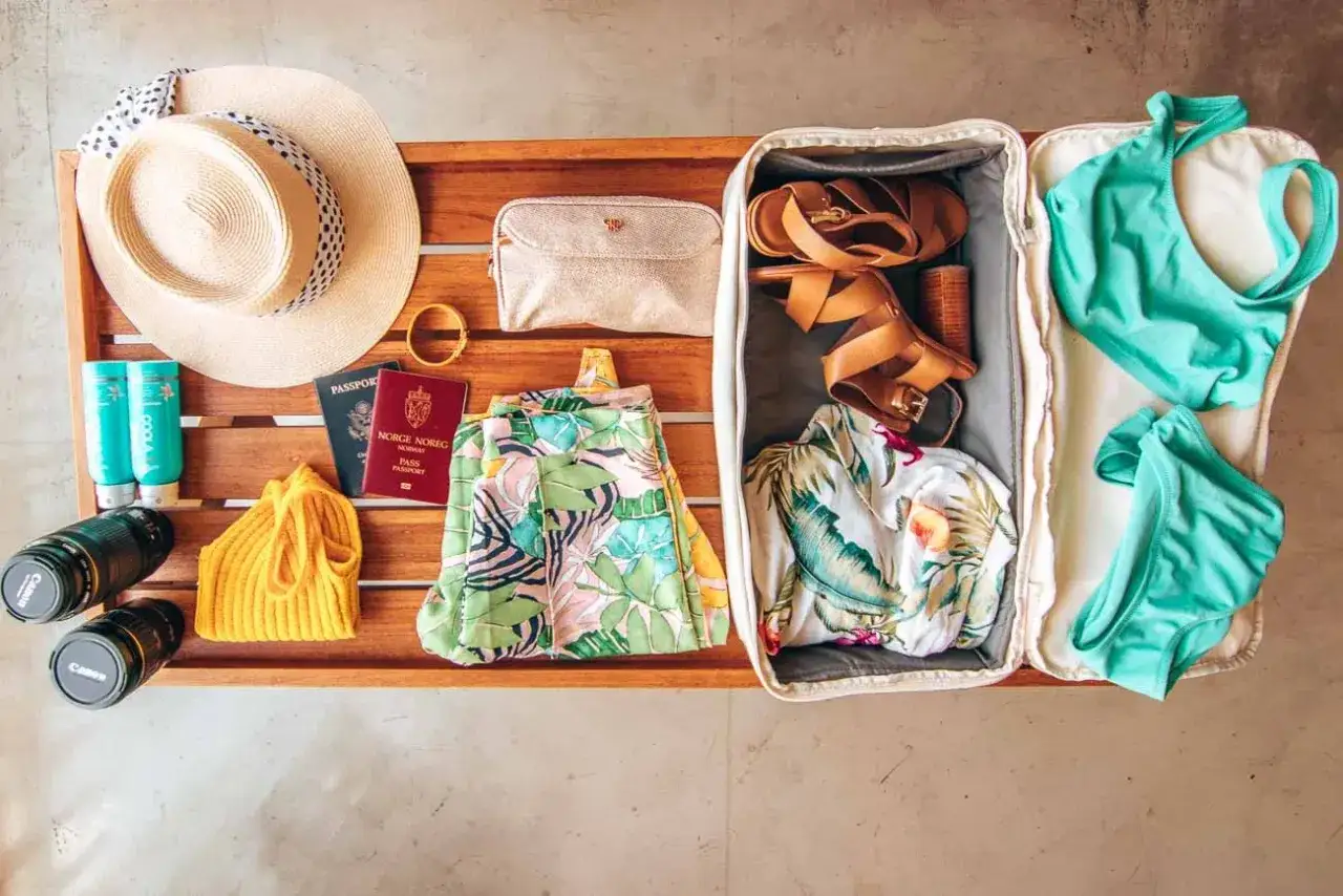 Packliste f&uuml;r eine tropische Insel: Sonnenhut, Reisep&auml;sse, Badesachen, Sandalen und Kamera f&uuml;r unvergessliche Momente.