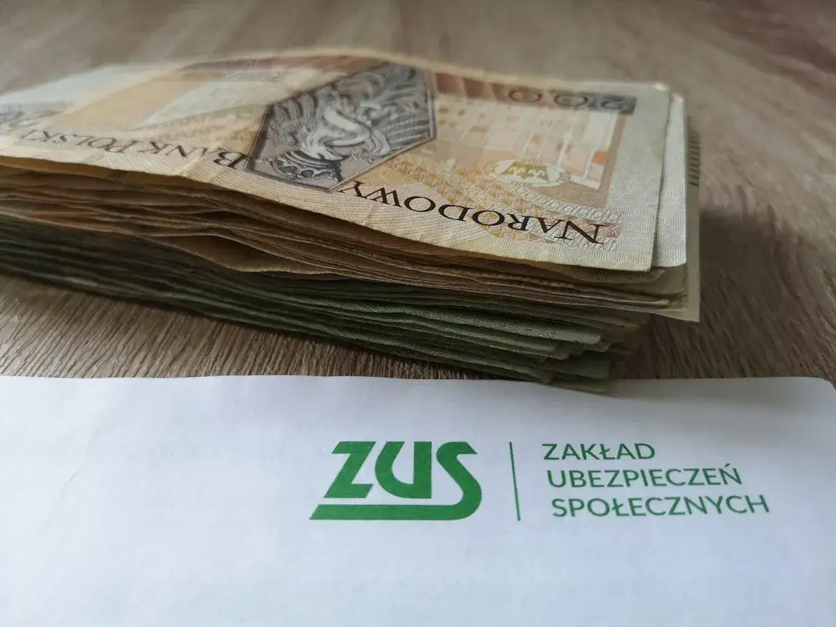 Stos banknotów i dokument ZUS. Pytanie: ile wynosi renta dla osoby niepełnosprawnej od urodzenia?