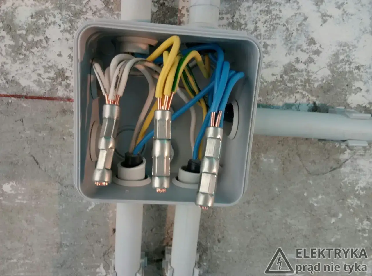 W skrzynce elektrycznej widać kolorowe przewody połączone za pomocą złączek elektrycznych.
