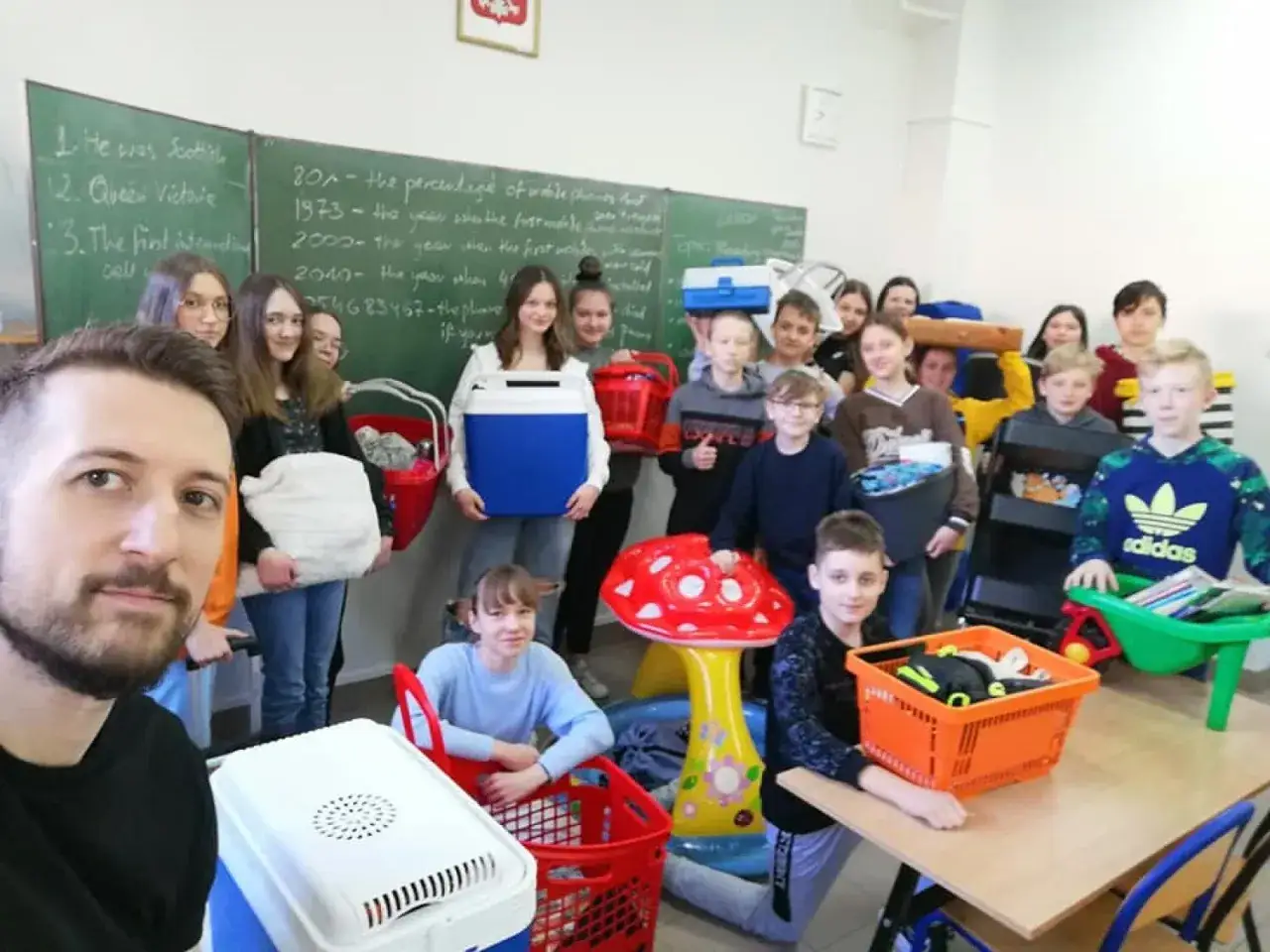 Uczniowie świętują dzień bez plecaka, niosąc przedmioty w koszach i lodówkach.