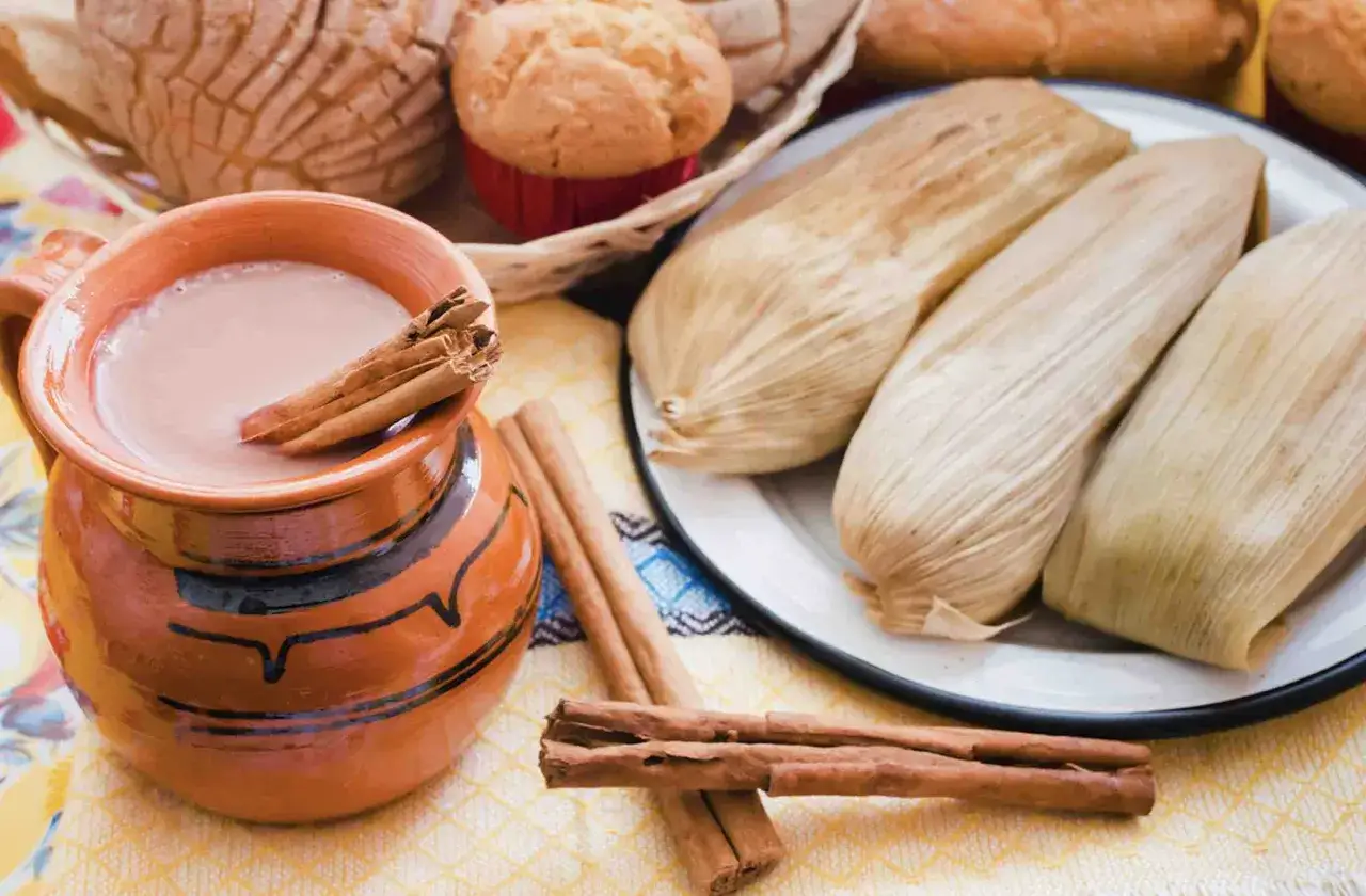 Tamales y atole en jarra de barro, con canela. Un fest&iacute;n que evoca lo que com&iacute;an los aztecas, con pan dulce y muffins.