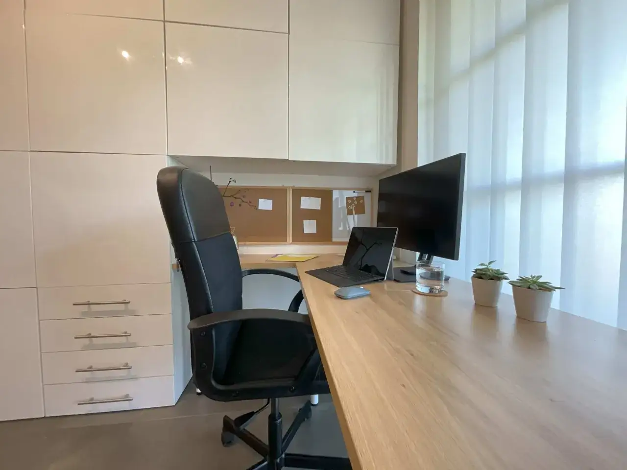 Bureau moderne avec chaise ergonomique, ordinateur portable, &eacute;cran et plantes pour une **optimisation bureau** r&eacute;ussie.