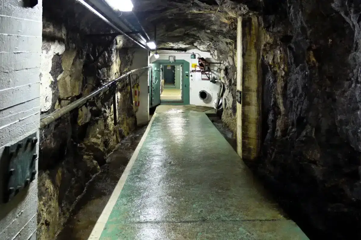 En lång, fuktig tunnel i berg med ståldörrar, en påminnelse om det kalla kriget och Sveriges beredskap.