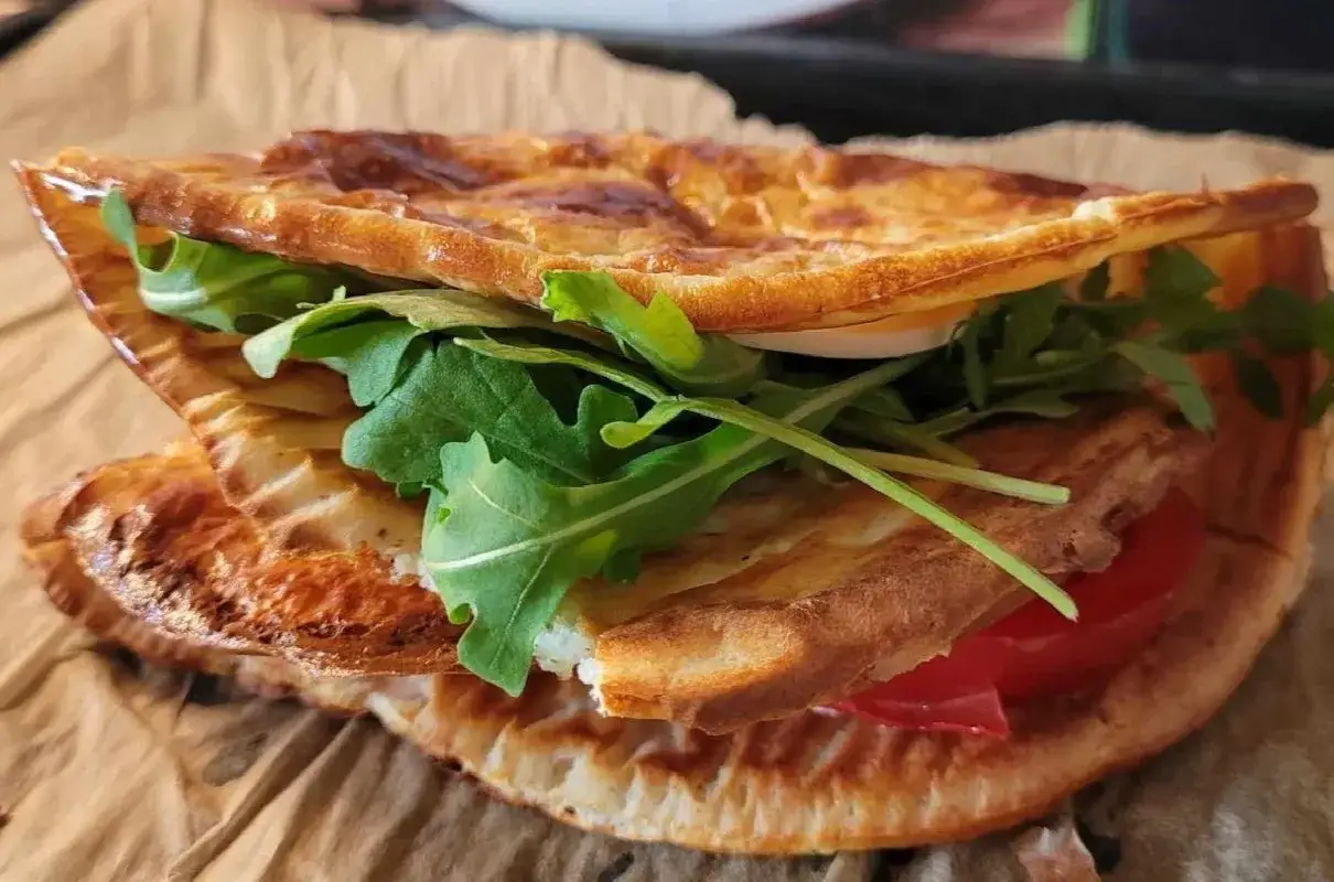 Pyszna tortilla z serka wiejskiego z rukolą i pomidorem, idealna na szybki lunch.