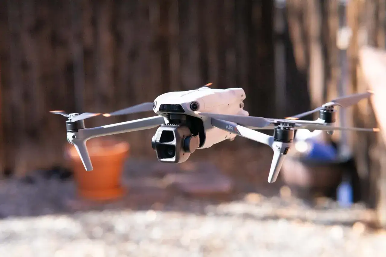 Biały dron DJI Air w locie, gotowy do porównania z innymi modelami.