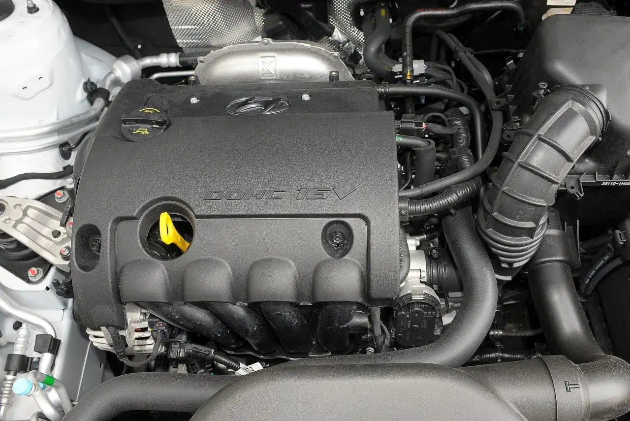 Silnik DOHC 16V w Hyundai i30 1.6 CRDi. Widoczny czarny plastikowy dekiel z logo Hyundai, żółta miarka oleju i elementy układu dolotowego.