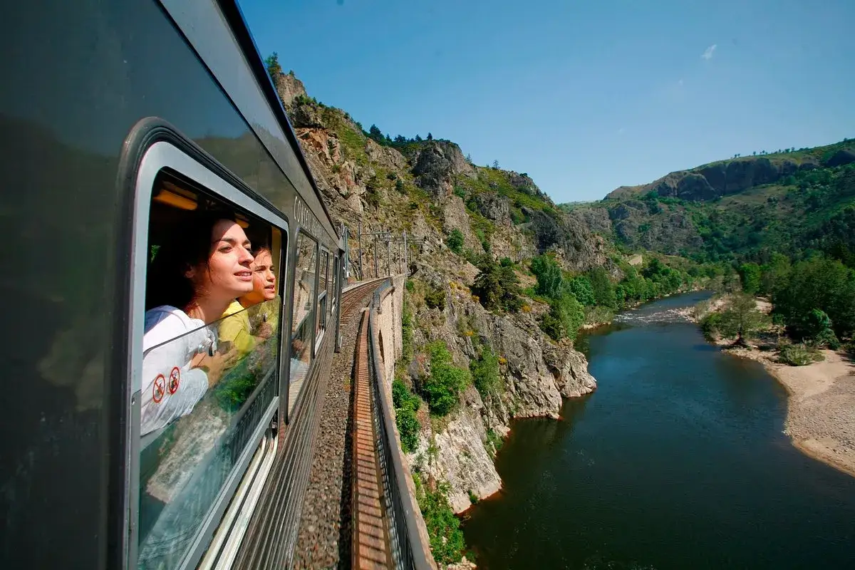 Deux jeunes femmes regardent par la fen&ecirc;tre d'un train traversant un paysage montagneux. Une id&eacute;e pour que faire ce dimanche dans le 43.