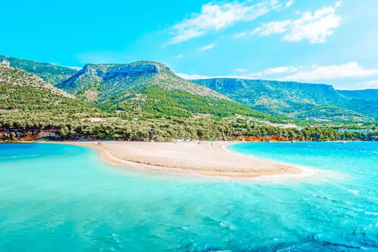 Piękna plaża Zlatni Rat, idealna na jednodniowe rejsy ze Splitu. Turkusowe morze i zielone wzgórza.