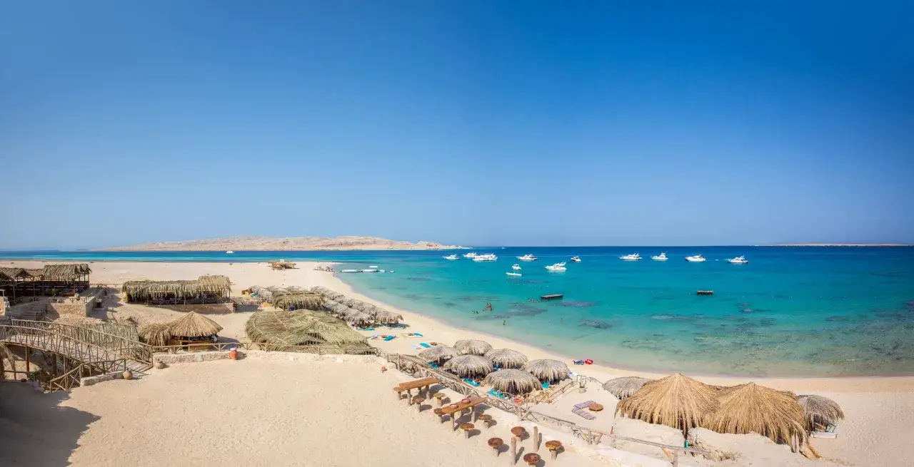Piękna plaża z palmowymi chatkami i łodziami na turkusowym morzu. Czy to Hurghada czy Marsa Alam?