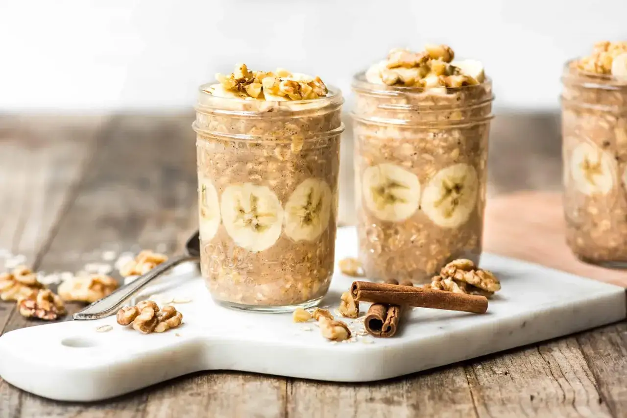 Gesundes Bananenbrot-Rezept: Haferflocken-Overnight-Oats im Glas mit Bananenscheiben, N&uuml;ssen und Zimt. Perfekt f&uuml;r ein nahrhaftes Fr&uuml;hst&uuml;ck.