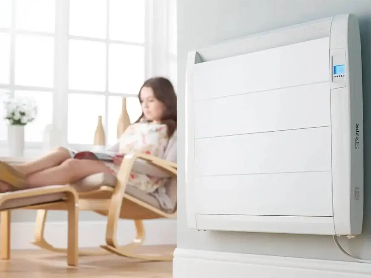 Mujer relajada leyendo, mientras un radiador eléctrico emite un agradable calor azul.