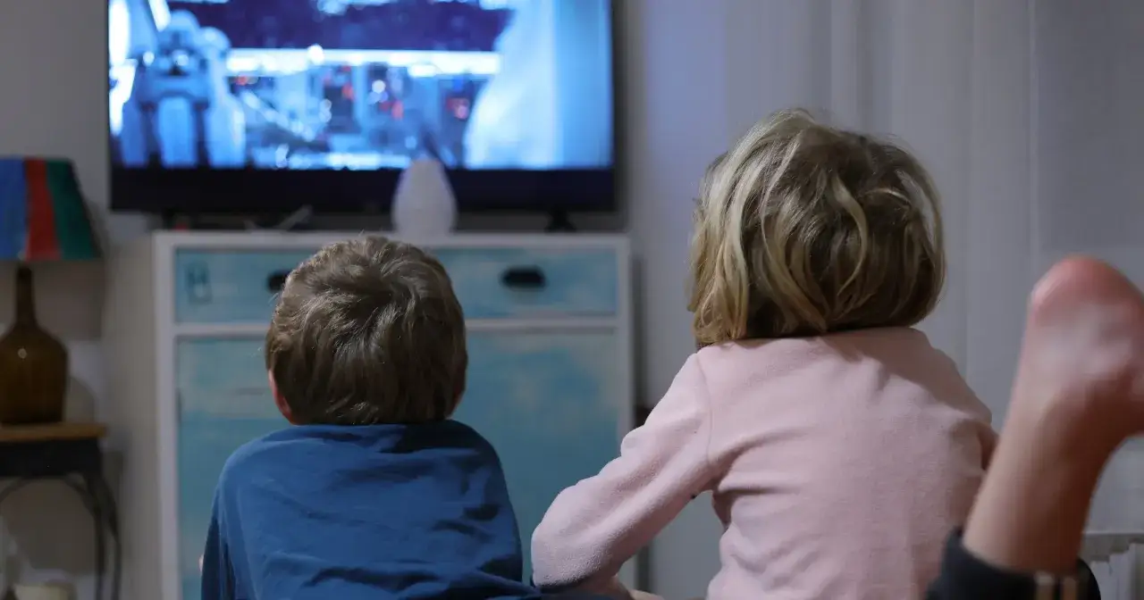Dzieci oglądają kr&oacute;tkie filmy dla dzieci na telewizorze.