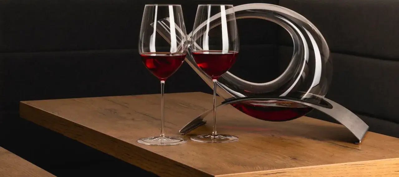 Zwei Weingl&auml;ser und ein Dekantierkrug mit Rotwein. Dekantiert bedeutet, den Wein in den Krug umzuf&uuml;llen, um ihn atmen zu lassen.