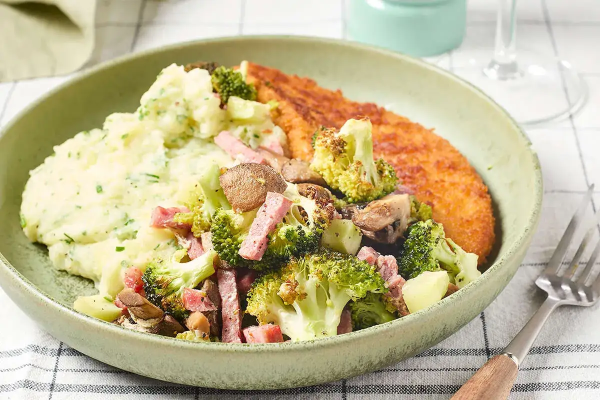 Une escalope de dinde dor&eacute;e c&ocirc;toie une pur&eacute;e onctueuse et un m&eacute;lange color&eacute; de brocolis, champignons et d&eacute;s de jambon.