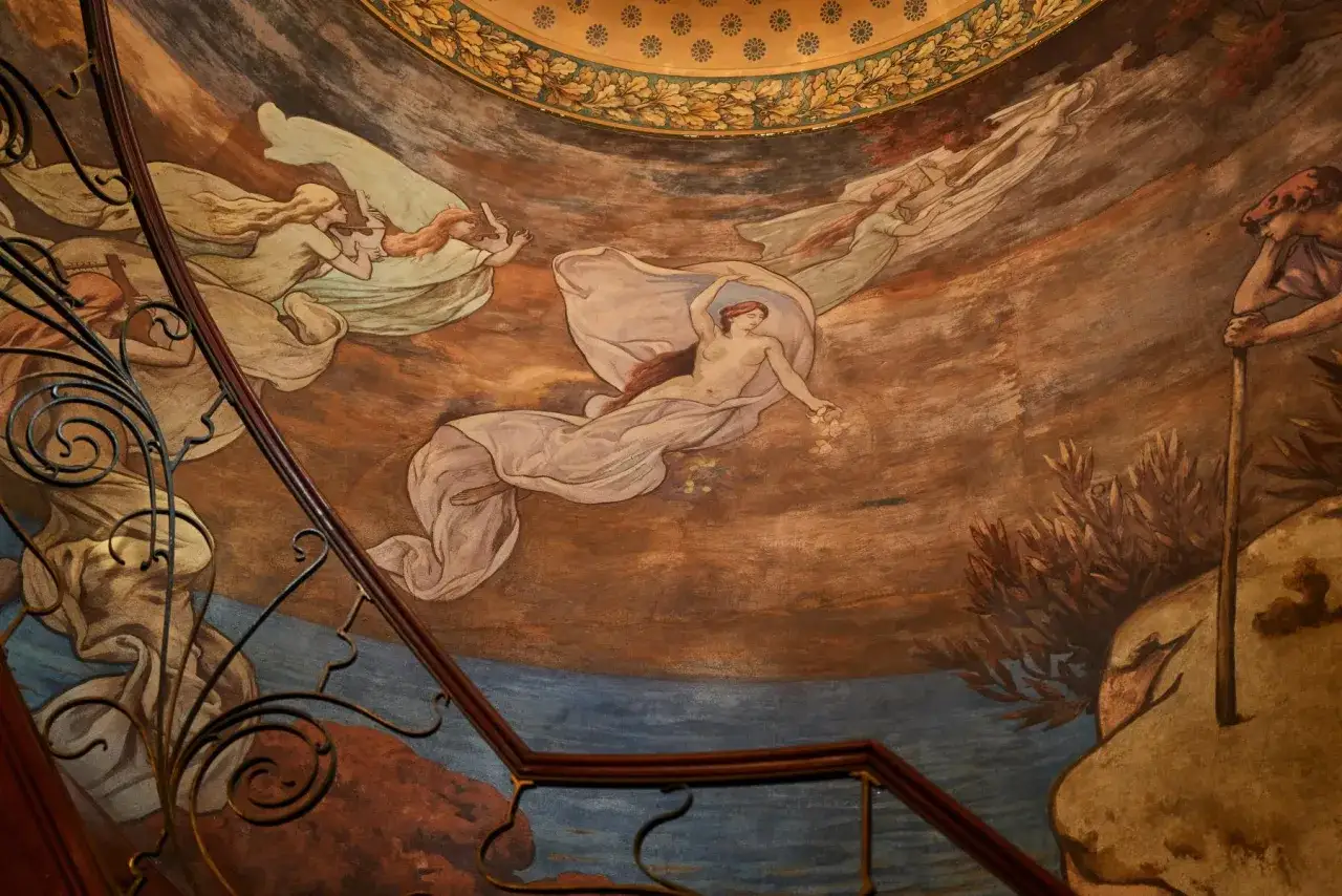 Peinture murale d'un peintre belge : des figures féminines éthérées flottent dans un ciel onirique, drapées de voiles légers.