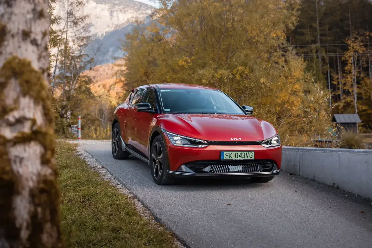 Czerwona Kia EV6 GT na tle jesiennego krajobrazu.