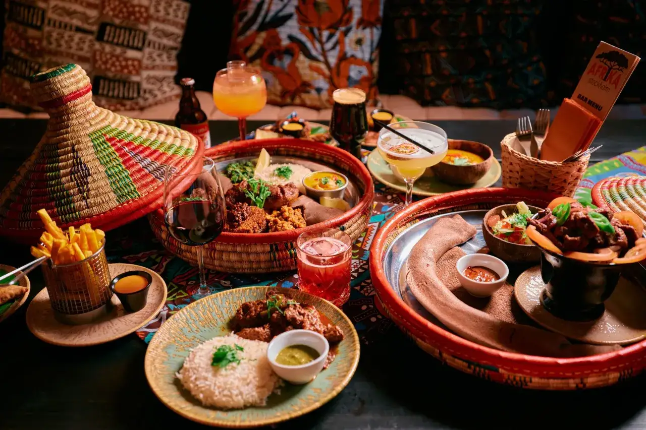En härlig måltid på en afrikansk restaurang med flera rätter, drycker och en färgglad duk.