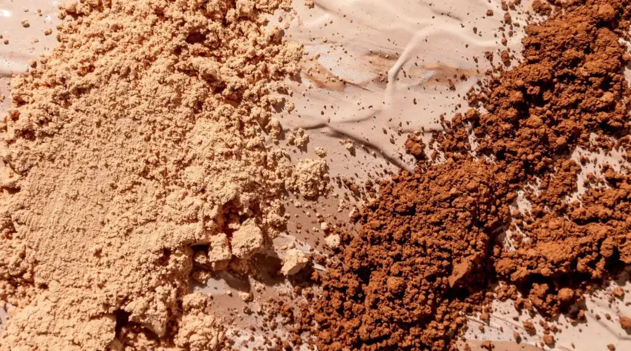Polveri di fondotinta chiaro e scuro, con tracce di crema, ingredienti come l'aluminum starch octenylsuccinate.
