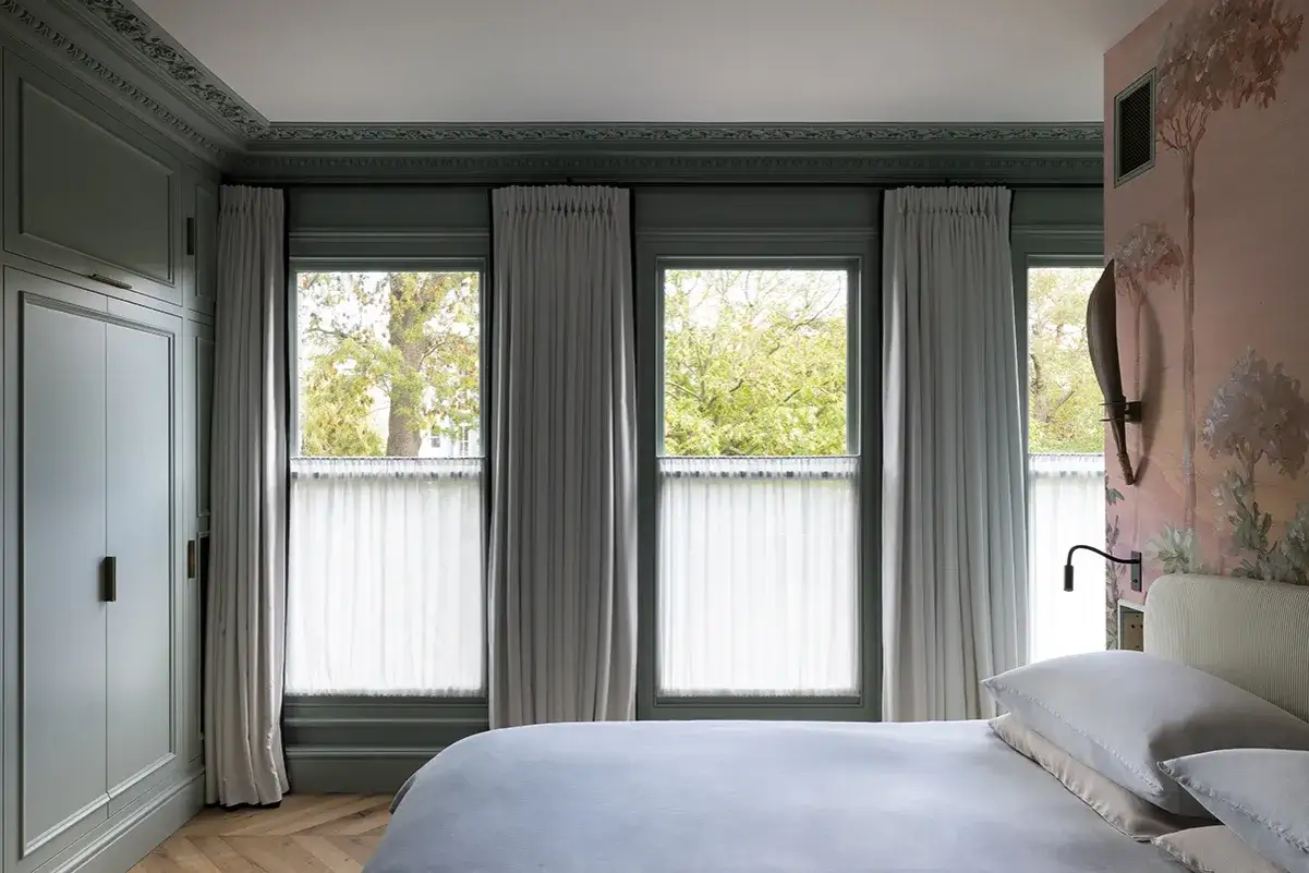 These elegant, floor-to-ceiling curtains frame a serene bedroom, proving that curtains are far from out of style.