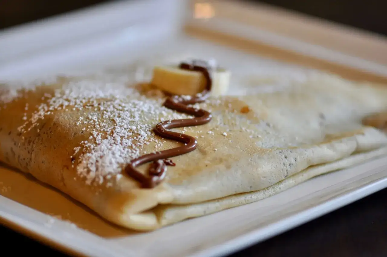 Délicieux crepe à la bière, saupoudré de sucre glace, avec un filet de chocolat et une rondelle de banane. Un vrai régal !