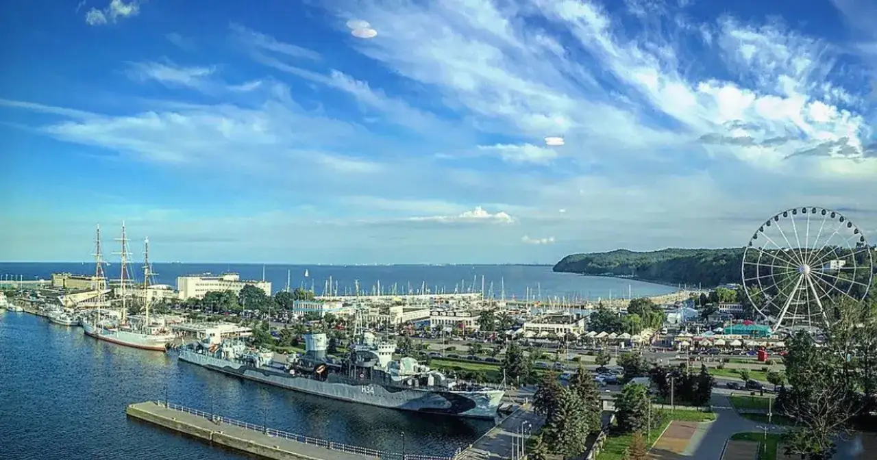 Widok na port w Gdyni: statki, żagl&oacute;wki, molo i diabelski młyn. Idealne miejsce, by zobaczyć, co zobaczyć w Gdyni.