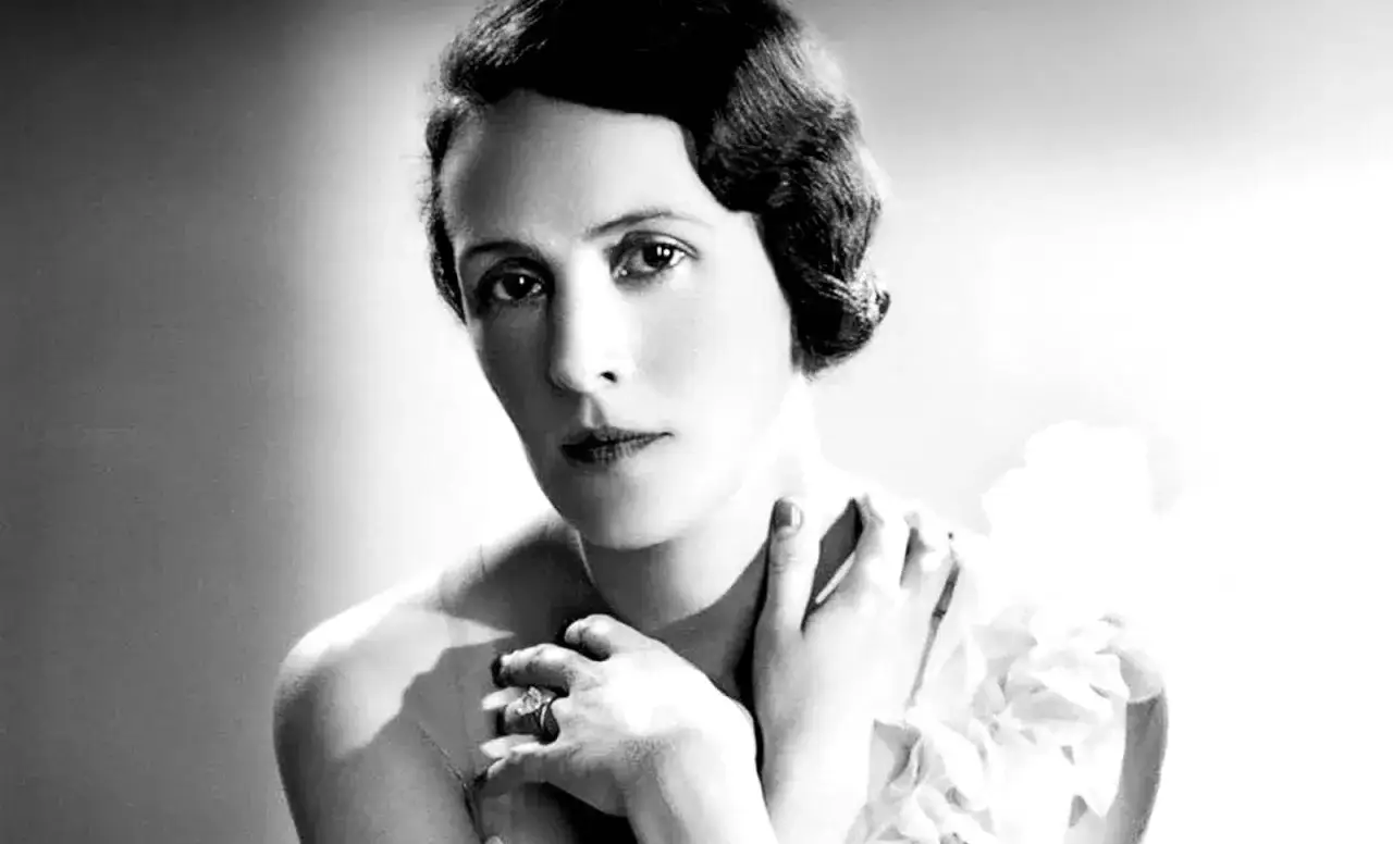 Portrait en noir et blanc de Marie Blanche de Polignac, &eacute;l&eacute;gante, avec une coiffure courte et un bijou &agrave; la main.