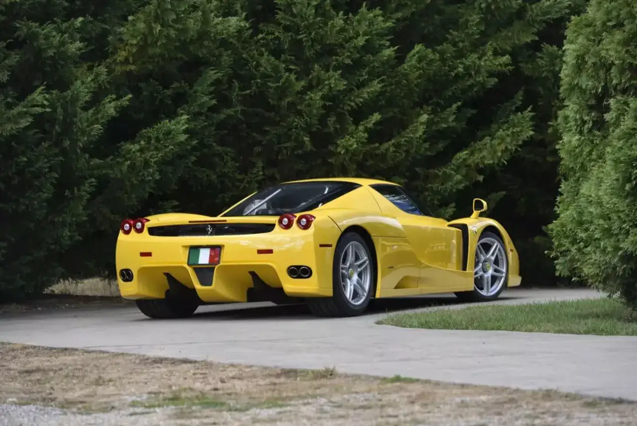 Żółte Ferrari Enzo na tle zieleni. Zastanawiasz się, ile kosztuje Ferrari Enzo?