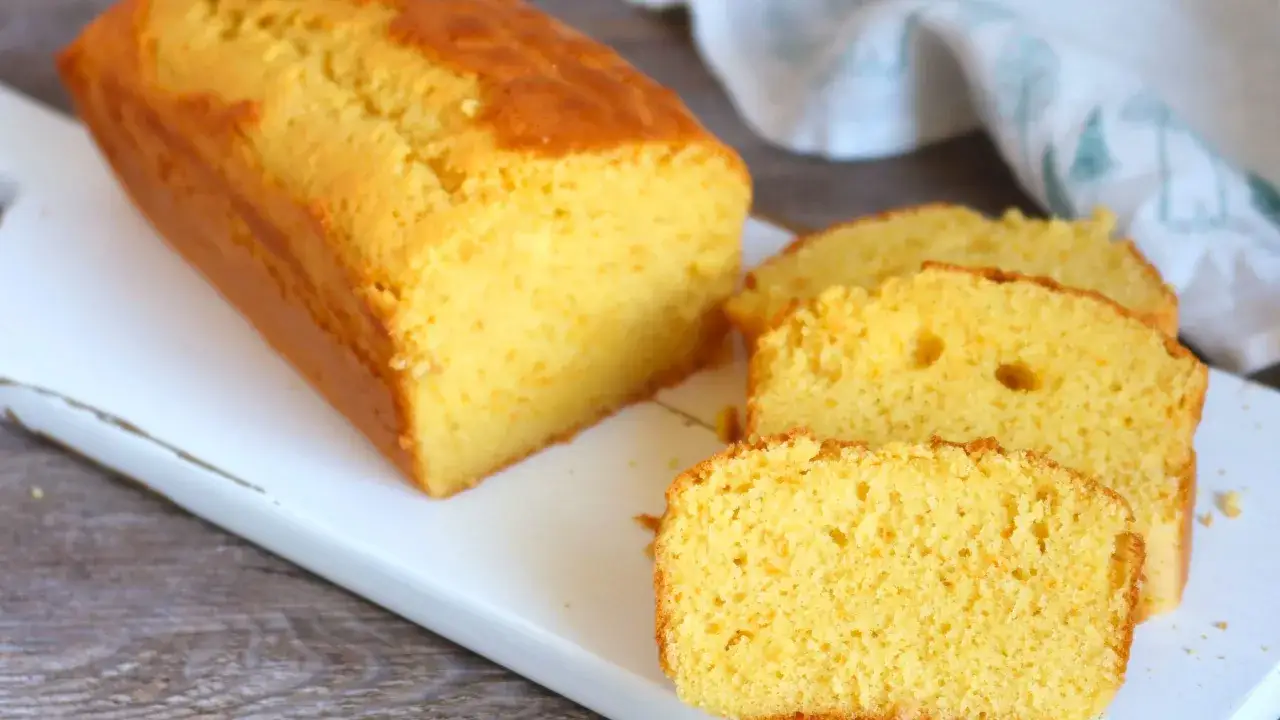 Bizcocho de naranja casero, dorado y esponjoso, con varias rebanadas listas para disfrutar.
