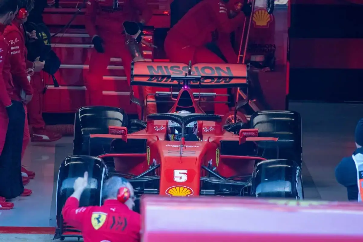 Ein Ferrari-Formel-1-Auto mit der Startnummer 5 steht in der Boxengasse. Die Frage, wie viel verdient ein Formel 1 Fahrer, ist angesichts dieses Anblicks berechtigt.