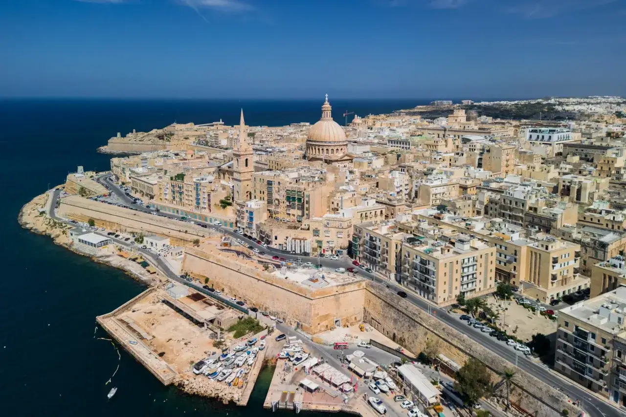 Widok na Vallettę, stolicę Malty. Czy Malta to miasto? Tak, to piękne miasto z kopułą katedry i fortyfikacjami nad morzem.