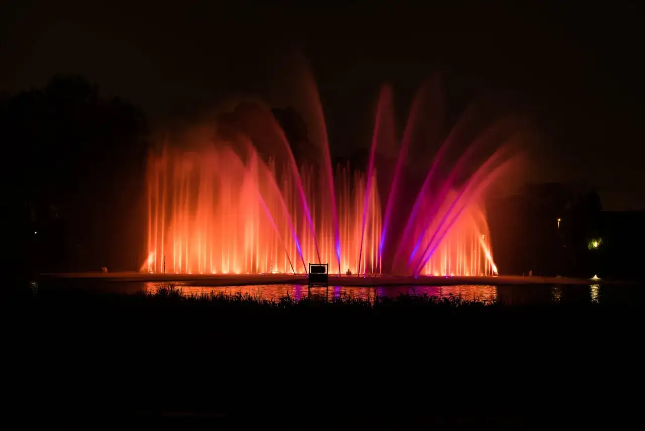 Spektakuläre Wasserspiele in Planten un Blomen tauchen die Nacht in leuchtendes Orange und Pink.