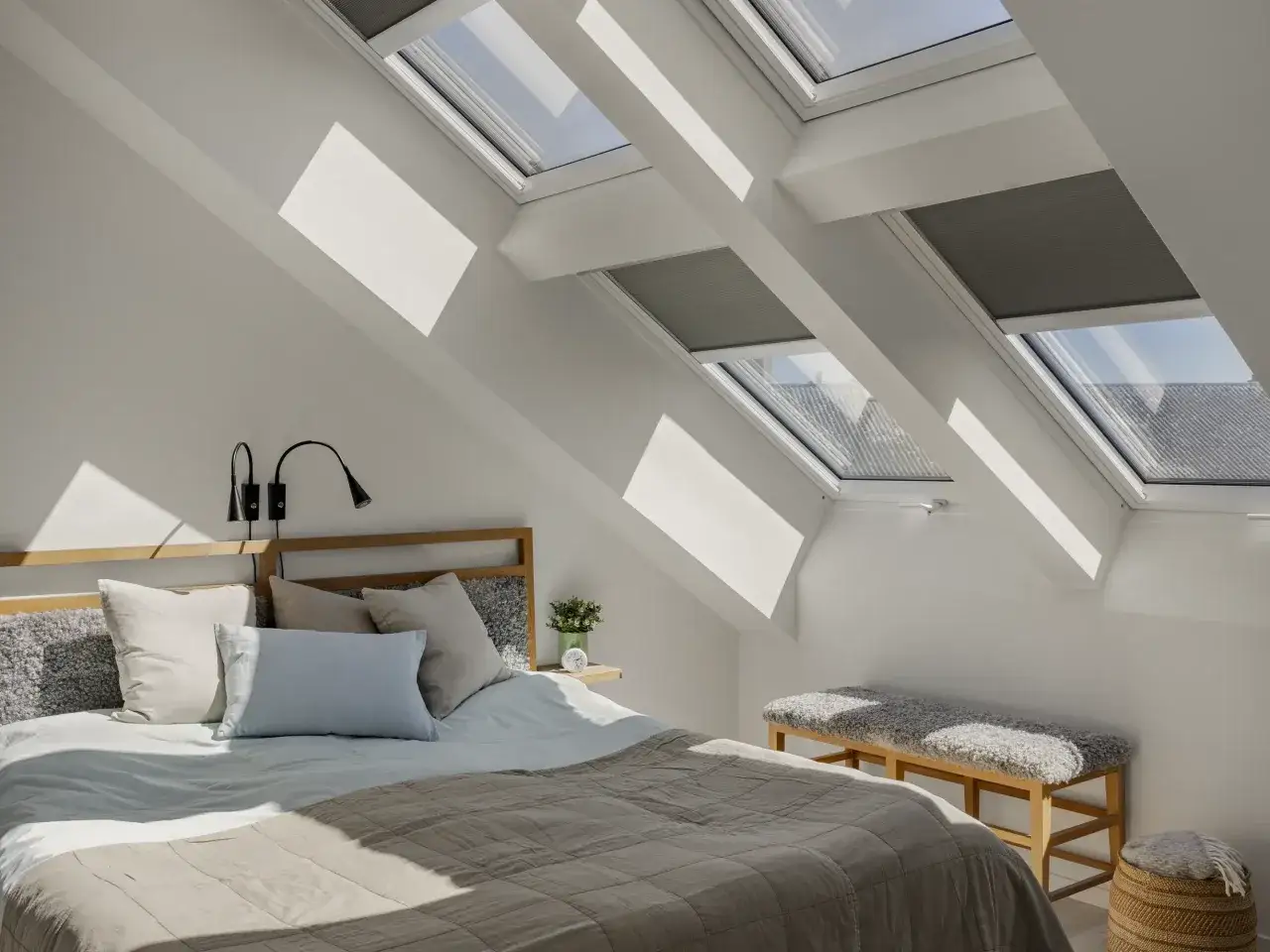 Helles Schlafzimmer mit Dachfenstern, die viel Licht hereinlassen. Gemütliches Bett mit Kissen und Decken. Perfekt zum schlafzimmer einrichten.