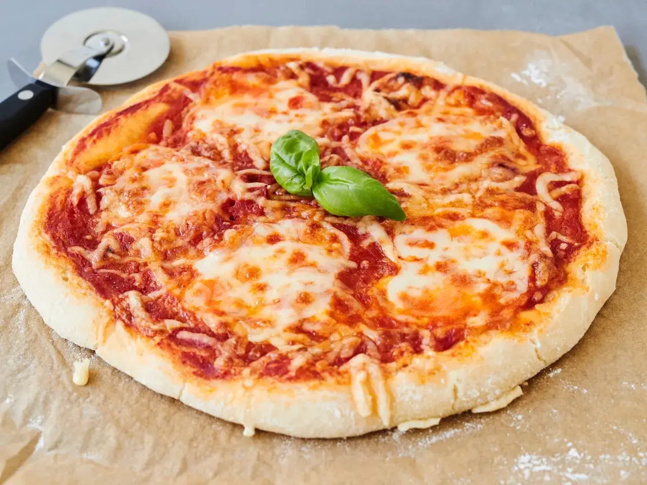 Eine köstliche, frisch gebackene glutenfreie Pizza mit geschmolzenem Käse und Basilikum. Perfekt für ein einfaches glutenfreies Pizza Rezept.