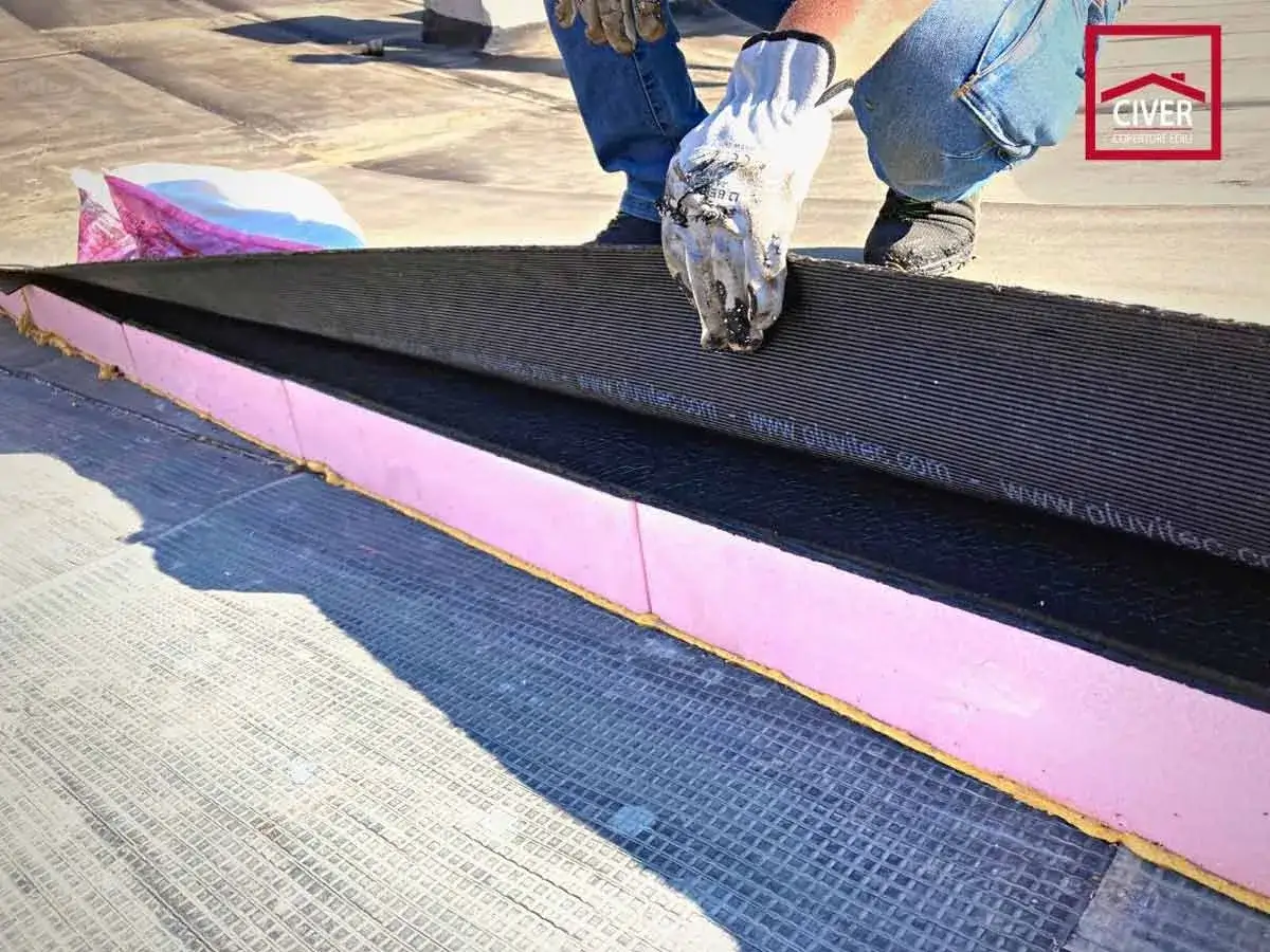 Installazione di isolamento termico per un maggiore comfort abitativo. Strati di materiale isolante rosa e membrana impermeabile su un tetto.