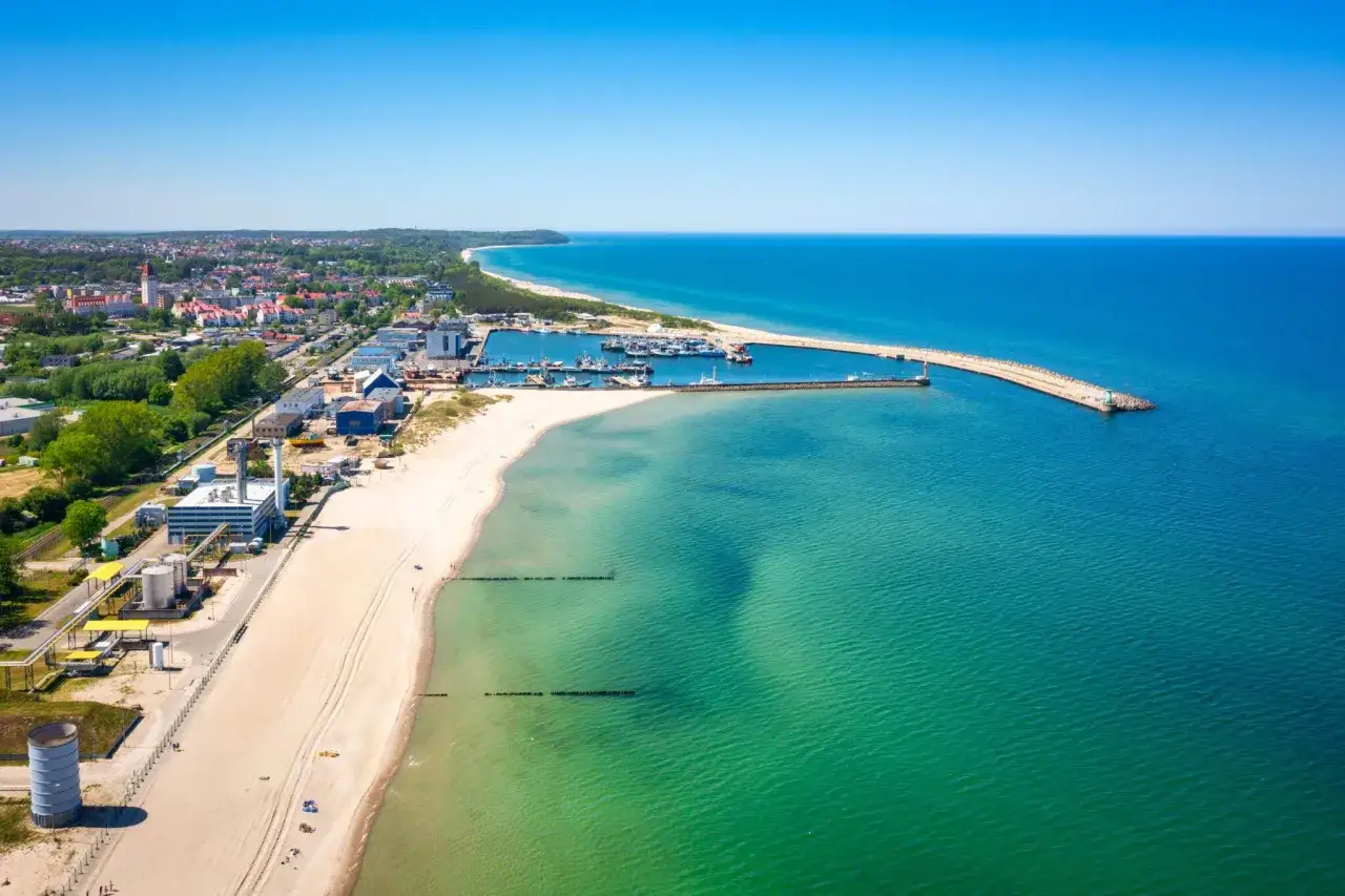 Władysławowo atrakcje: aerial view of the town, beach, port with boats, and the Baltic Sea on a sunny day.