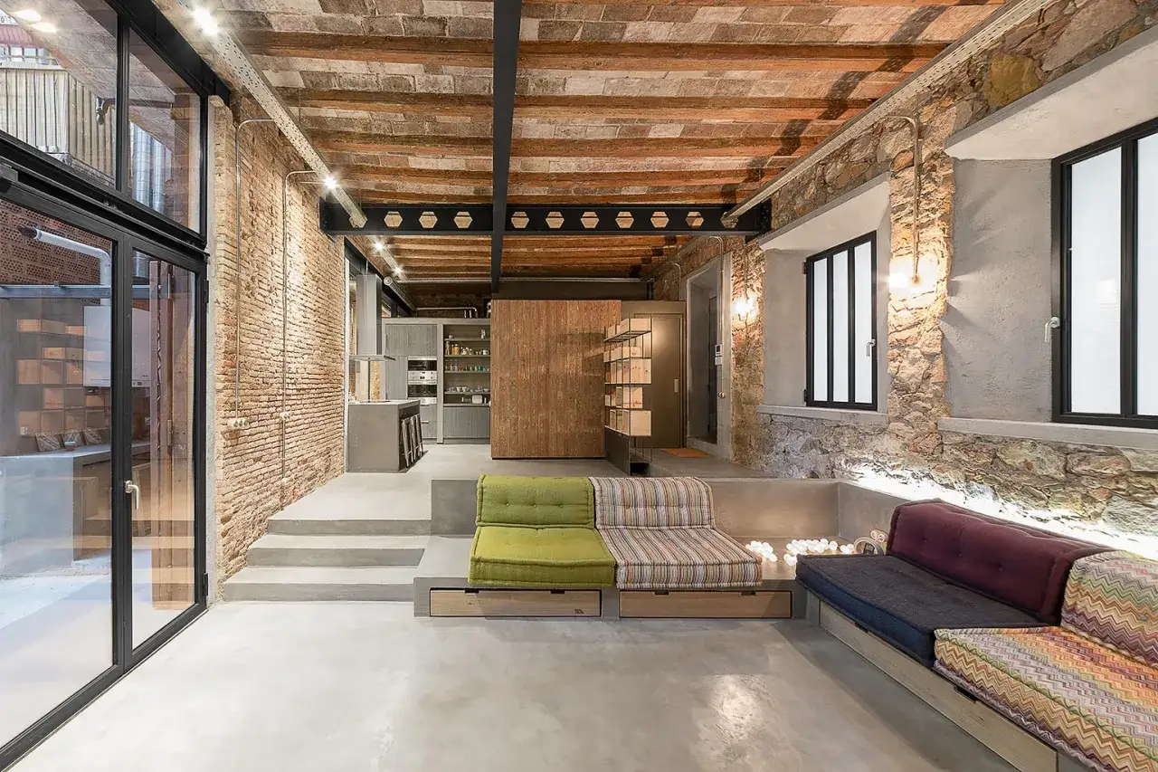 Espacio diáfano con estética industrial, ideal para un estudio de arquitectura e interiorismo. Ladrillo visto, vigas de madera y hormigón.