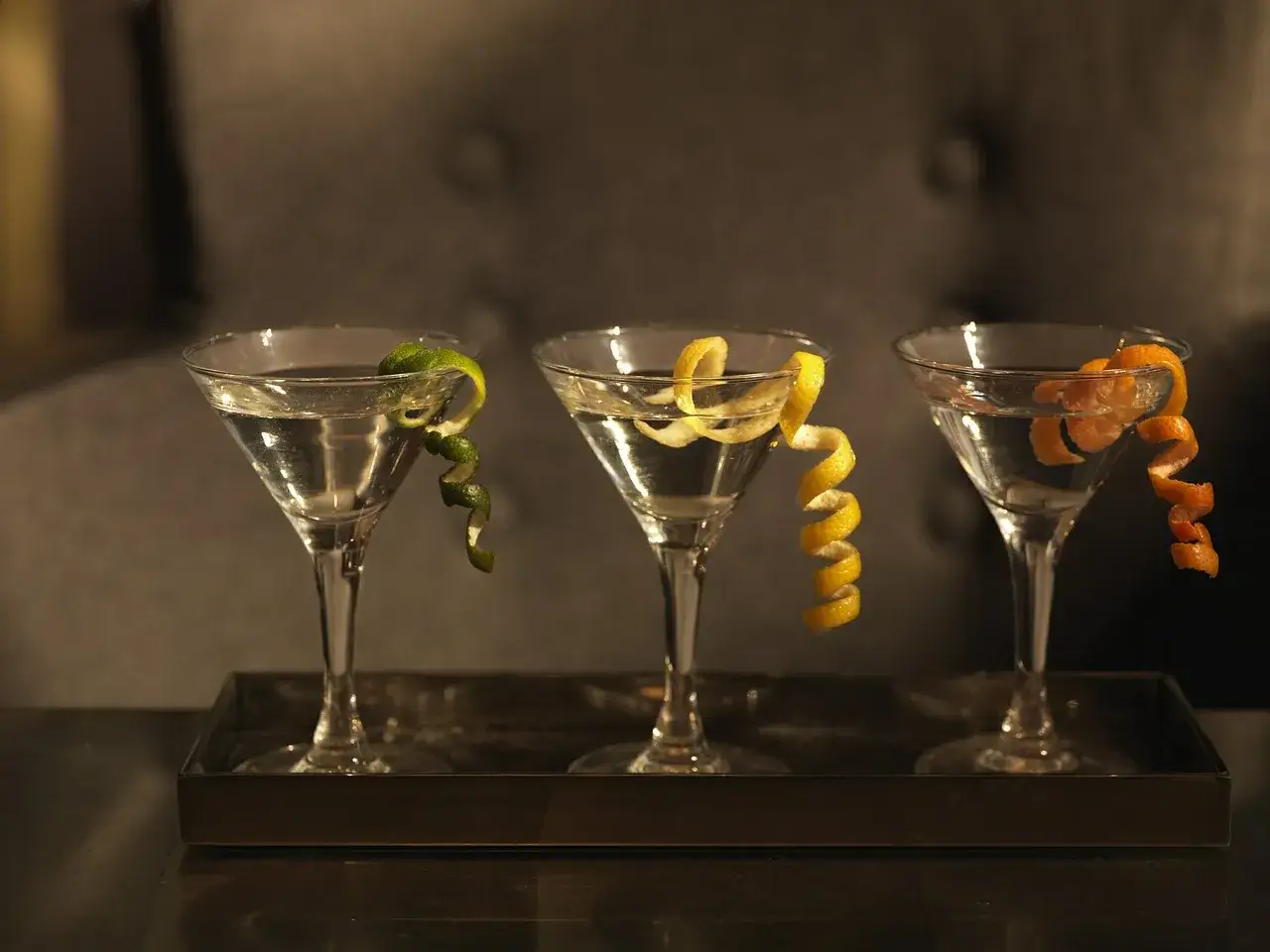 Różne warianty Martini w kieliszkach: Dirty Martini z oliwkami, Vesper Martini, klasyczne Vodka Martini