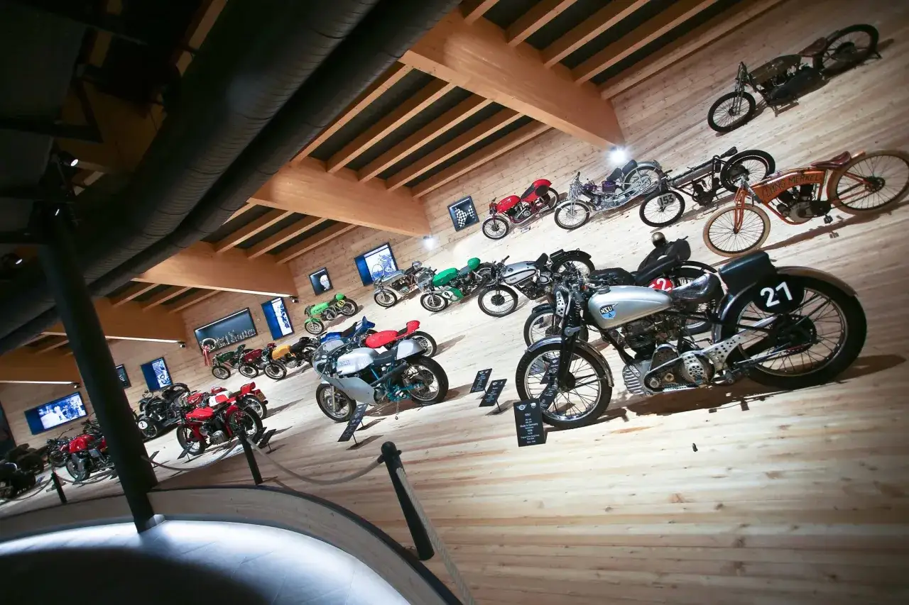 Collezione di moto d'epoca in un museo, tra cui una con il numero 21. Un viaggio nella storia del motociclismo al museo moto passo rombo.