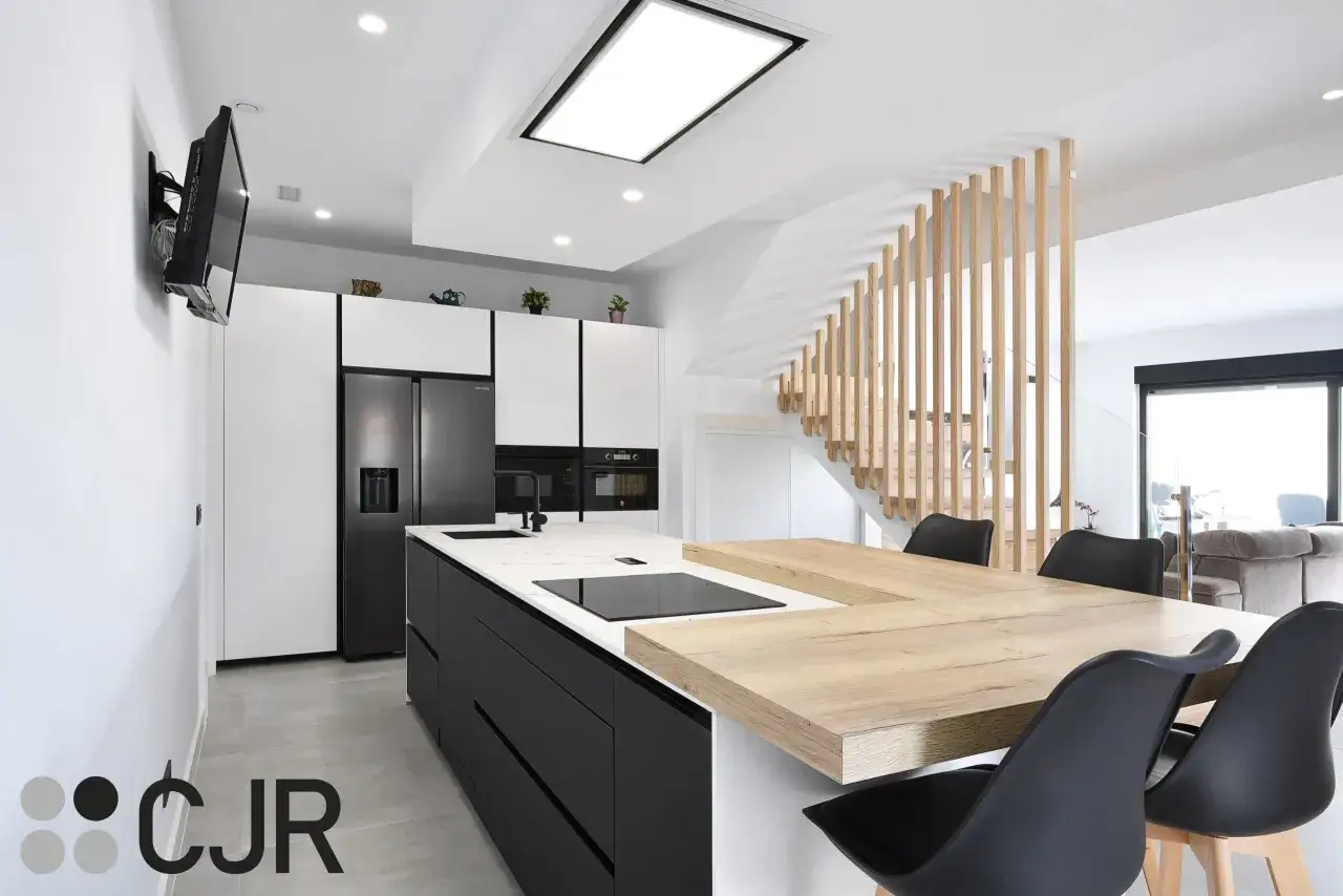 Elegantes **diseños de cocinas** modernas con isla central, electrodomésticos integrados y una escalera de madera.