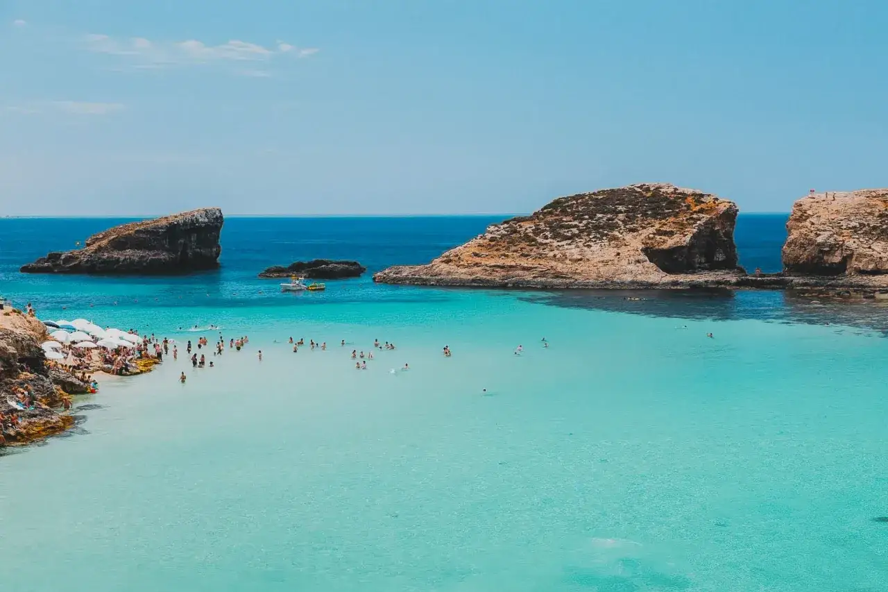 Błękitna woda, skały i plażowicze. Czy Malta, warto? Tak, to raj dla miłośników słońca i kąpieli.
